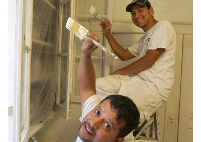 A Man Sitting on a Ladder With a Paint Brush