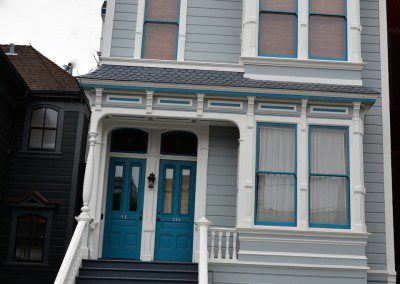 A Victorian Building With Teal Color Frame